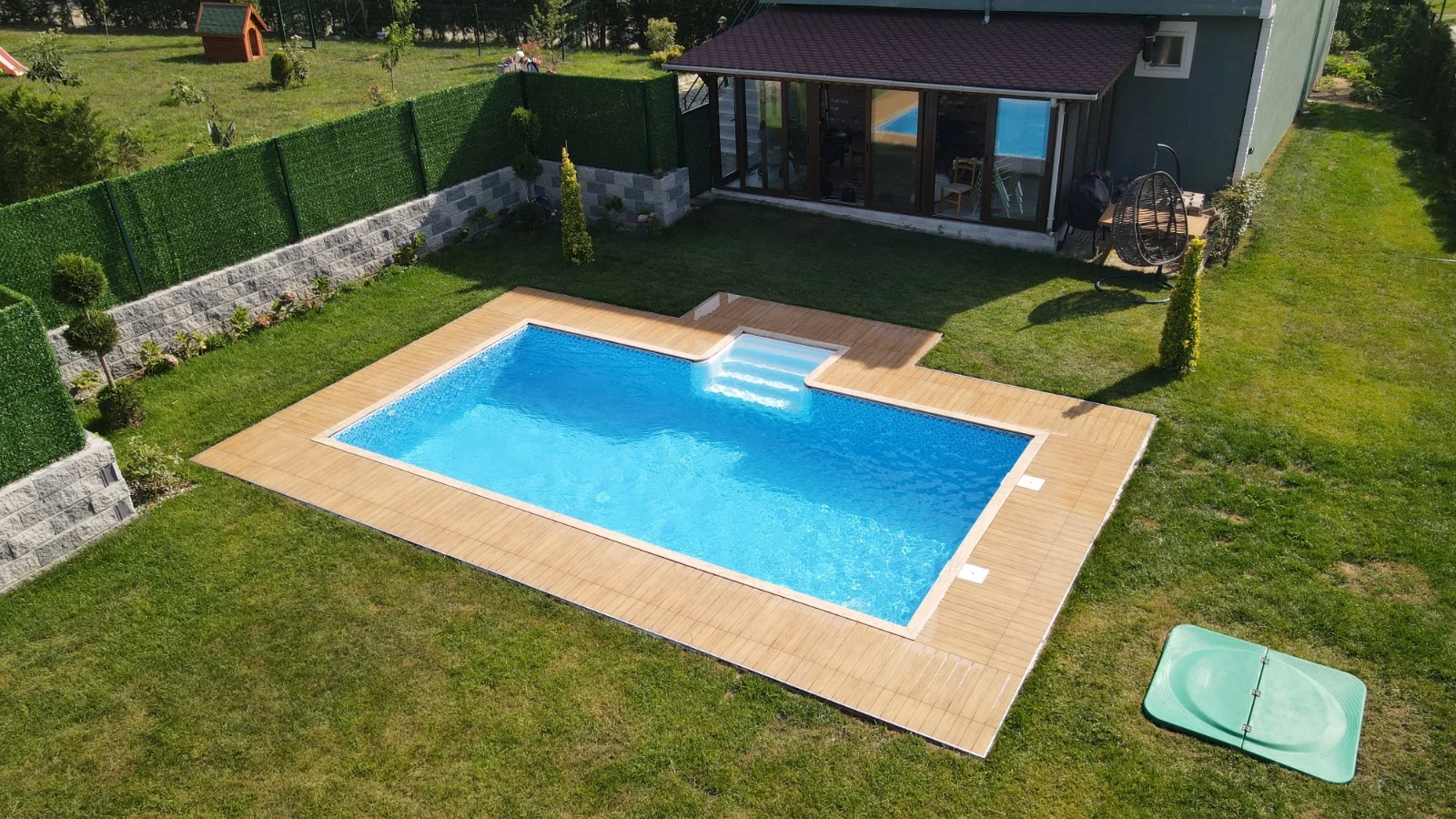 Çim bahçede Fiplus havuz ve ahşap deck
